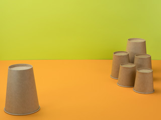 Paper cups in the bright orange and green background.