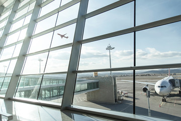 An empty terminal, aircrafts are waiting and preparing for their next flight and one of them taken...