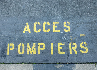 yellow fire brigade access markings on a blue asphalt surface
