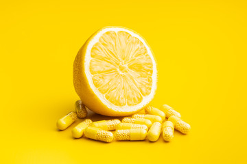 Vitamin capsules. Vitamin C pills and yellow lemon.