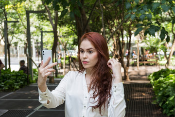 Gorgeous redhead woman making a selfie with a smartphone