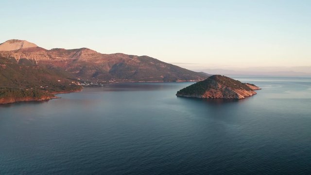 Drone flight around the mountain slopes and rocky coastline of Thasos island and the little island Nisida Kinira, Greece