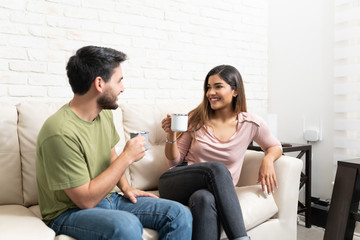 Smiling Latin Couple Having Coffee At Home