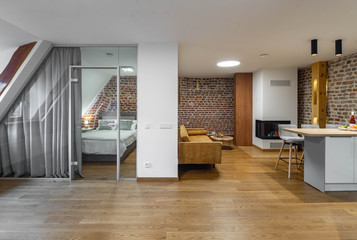 Modern contemporary interior of studio apartment. Private house. Brick wall. Kitchen set.