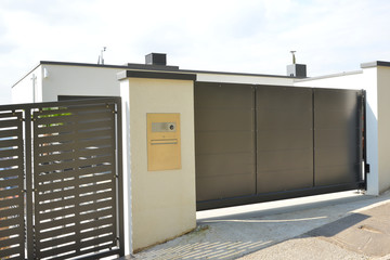 Elektrisch betätigtes Edelstahltor in der Hofeinfahrt vor einem Wohnhaus © Hermann
