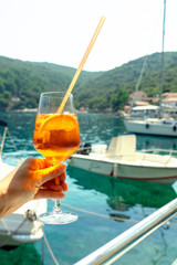Fototapeta na wymiar Drinking Cocktail long drink in the harbour bay with boats on a boat