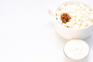 Breakfast concept. cottage cheese with walnuts, sour cream on a light background and a towel. white