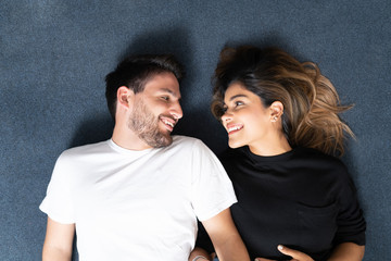 Happy Boyfriend And Girlfriend Lying On Carpet