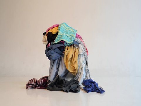 pile of clothes on a white background on which other clothes are flying