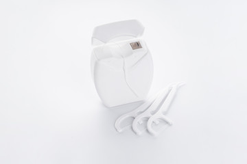 White dental floss packaging with white toothpicks and floss on a white background. Is isolated.