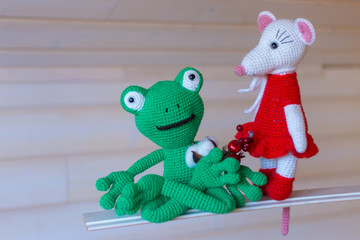 Amigurumi dolls rat and frog posing for the photographer.