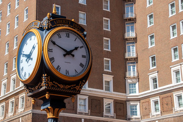 Fototapeta na wymiar The Liberty Clock with a brick hotel in the background in downtown Greenville, South Carolina