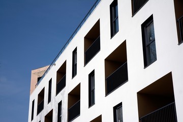 Exterior of new apartment buildings on a blue cloudy sky background. No people. Real estate business concept.