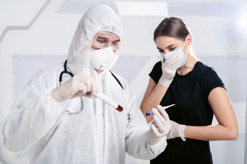 Naklejka premium Pandemic covid-19. A virologist doctor holding a patient’s blood sample in test tube and thermometer. An infected girl coughs in the background. Disease vaccine development