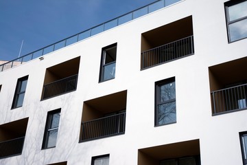Exterior of new apartment buildings on a blue cloudy sky background. No people. Real estate business concept.