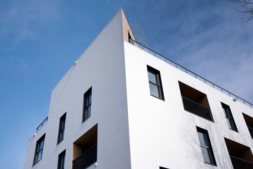 Exterior of new apartment buildings on a blue cloudy sky background. No people. Real estate business concept.