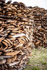 Chopped dry firewood prepared for winter lie exactly stacked one on one on the street. Background of logs, birch, pine and oak..