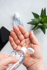 Hand cleaning gel. Pouring sanitising hand gel onto a woman hand
