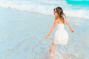 Fototapeta na wymiar Adorable happy little girl have fun on beach vacation