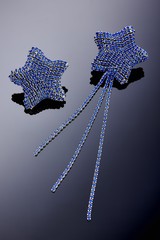 Obraz premium Plastic jewelry earrings with crystals and stones for women on a dark background.