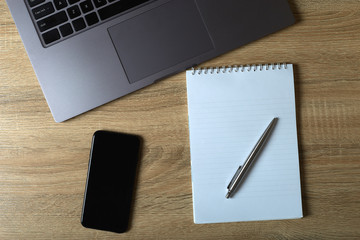 Remote work laptop phone notepad with pen on the table