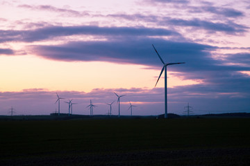 Fototapeta na wymiar wind generators in the counter sky at sunset