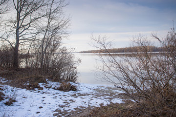 Fototapeta na wymiar Winter river landscape. Beautiful clouds over the water
