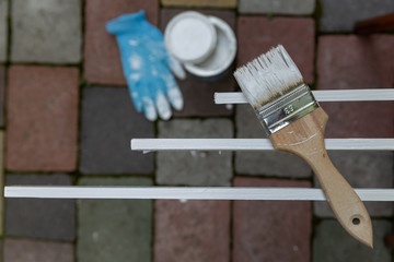 paint brush covered with white paint on painted strips on a dark background