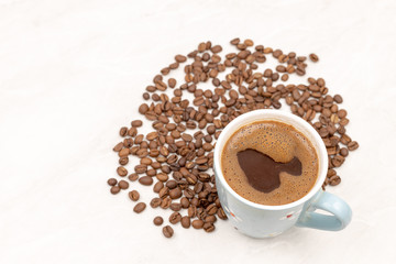 Cup Of Black Coffee With Coffee Beans On The White Table