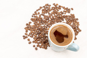 Cup Of Black Coffee With Coffee Beans On The White Table