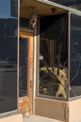 Cracked glass window pane by shop door looking like rioters have tried to enter the store