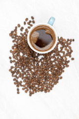 Cup Of Black Coffee With Coffee Beans On The White Table