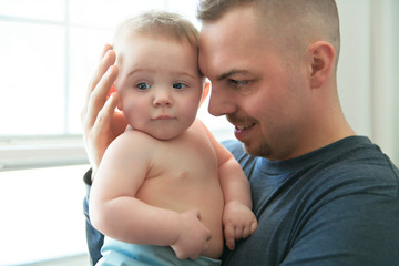 the father hugging her baby with a sad face and eyes