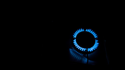One burner with blue flames in a black background