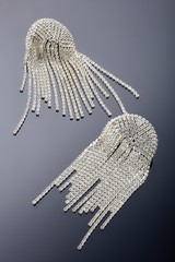 Plastic jewelry earrings with crystals and stones for women on a dark background.