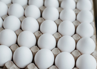 Tray of white fresh eggs close-up on a cardboard form. Agricultural industry