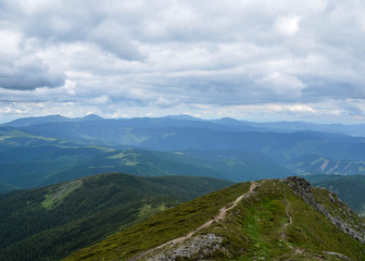 Fototapeta na wymiar Beautiful view of the mountain range Chornohora with its spurs in the Carpathian Mountains with cloudy sky in summer, Ukraine 