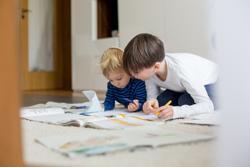 Child, doing school work on the floor at home while in quarantene