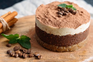  Tiramisu on a beige plate. Coffee with cinnamon. Raw dessert