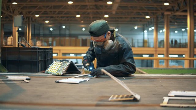 A man uses drill while preparing discarded garbage for recycling.