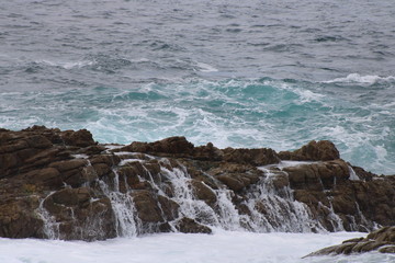 waves pouring down rock