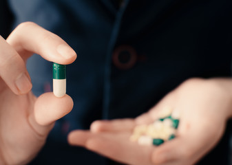 Medicine pills or capsules in hand. Pharmaceutical medicament. Antibiotic, painkiller closeup. Corona virus, COVID-19 OR 2019-nCov, the virus, concept for healthcare and medical.