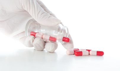 Hand with white gloves and glass bottle of antibiotic