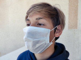 Teenager blond boy wearing medicine face mask for virus protection