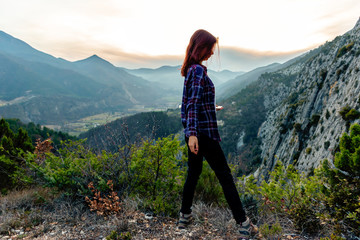 Fototapeta premium A full body shot of a young female hiker / adventurer in the French Alps mountains posing during sunset