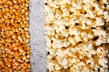 Flatlay of salted popcorn with cheese. Heap of homemade delicious popcorn on a rustic wooden table. Snacks and food for a movie theater or cinema. Fastfood background.  Strip texture