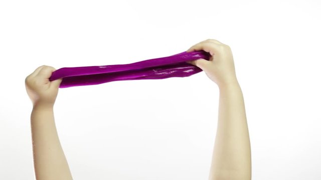 Child hands playing oddly purple slime on white background. Antistress