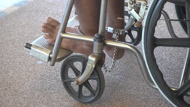 legs of the prisoner in chains sitting wheelchair in hospitals
