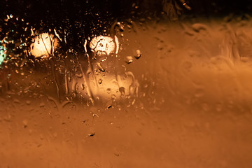 Drops of rain on glass against the background of the night city