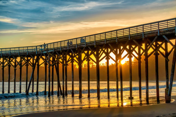 Fototapeta premium Silhouette of Pier Pylons at Sunset at Beach 